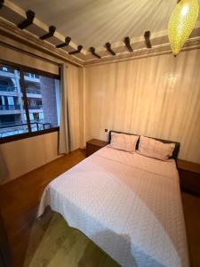 een slaapkamer met een wit bed en een raam bij Appartement pour les séjours in Marrakesh +8 foto's