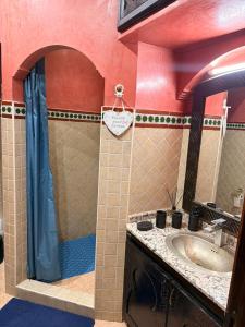 een badkamer met wastafel en douche met spiegel bij Appartement pour les séjours in Marrakesh