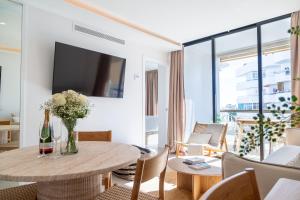 a living room with a table and a tv at Boutique Apartment with Sun Terrace & Sea Views in Torremolinos