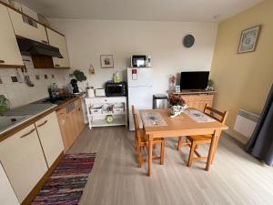 une petite cuisine avec une table et un réfrigérateur dans l'établissement Alisiers 18, à Eugénie-les-Bains 2 autres photos