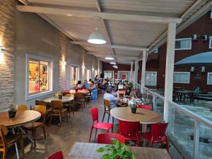 ein Restaurant mit Tischen und Stühlen und Menschen, die an den Tischen sitzen in der Unterkunft PARQUE AQUÁTICO Lagoa Quente, à 50m, entrada + barata, apto particular in Caldas Novas