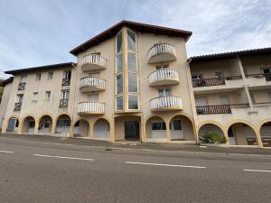 un grand bâtiment avec des balcons sur le côté d'une rue dans l'établissement Alisiers 18, à Eugénie-les-Bains