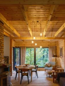 a living room with a wooden ceiling and a table at Domek nad jeziorem w górach in Międzybrodzie Bialskie