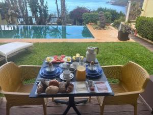 a tray of food on a table on a patio at Suite Vigia Jardim in Jardim do Mar