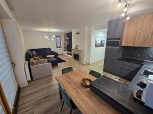 a kitchen and living room with a table and a couch at Apartman Nina in Donovaly