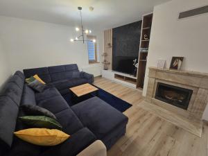 a living room with a blue couch and a fireplace at Apartman Nina in Donovaly