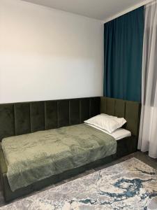 - un lit avec une tête de lit verte dans l'établissement Albert Studio, à Drobeta-Turnu Severin