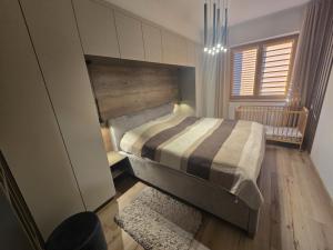 a bedroom with a bed in a room with a window at Apartman Nina in Donovaly