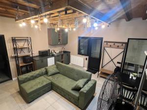 een woonkamer met een groene bank en een keuken bij M Town cotagge house 