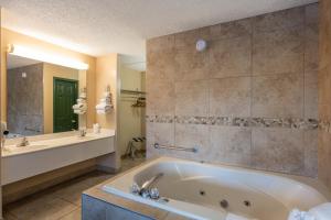 ein großes Badezimmer mit Badewanne und Waschbecken in der Unterkunft Angel Inn Near IMAX, a Travelodge by Wyndham in Branson