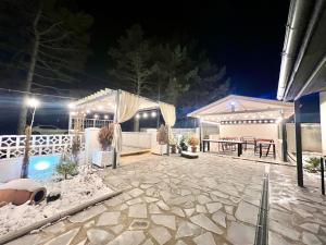 een patio met een tafel en 's nachts een zwembad bij M Town cotagge house  +7 foto's