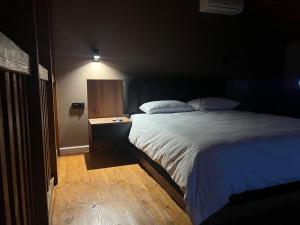 een slaapkamer met een groot bed en een nachtkastje bij M Town cotagge house 