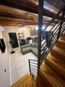 een woonkamer met een groene bank en een trap bij M Town cotagge house 