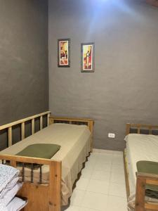 Zimmer mit 2 Betten und 2 Bildern an der Wand in der Unterkunft Cabañas Las Carditas in Mendoza