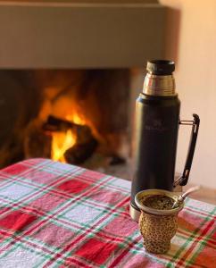 Eine Flasche Kaffee und eine Schüssel Kaffee auf einem Tisch in der Unterkunft Cabañas Las Carditas in Mendoza