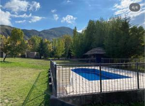einen Metallzaun um einen Pool in einem Hof in der Unterkunft Cabañas Las Carditas in Mendoza