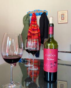 eine Flasche Wein und zwei Gläser auf einem Tisch in der Unterkunft Cabañas Las Carditas in Mendoza