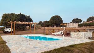 een zwembad met een stoel in de tuin bij Chácara pôr do sol in Sorocaba