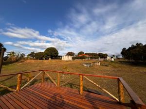 een houten vlonder die naar een omheind veld leidt bij Chácara pôr do sol in Sorocaba