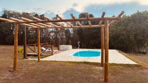 een houten pergola naast een zwembad bij Chácara pôr do sol in Sorocaba +2 foto's