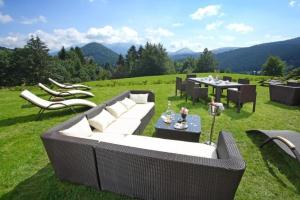 a patio with couches and tables in a field at Apartman Nina in Donovaly