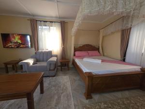 ein Schlafzimmer mit einem Bett und einem Sofa sowie einem Bett und einem Tisch in der Unterkunft The Hidden Paradise in Mombasa + 116 Fotos