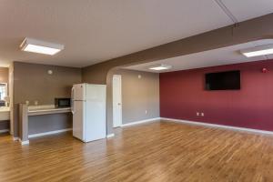 ein leeres Wohnzimmer mit einem weißen Kühlschrank in der Unterkunft Angel Inn Near IMAX, a Travelodge by Wyndham in Branson