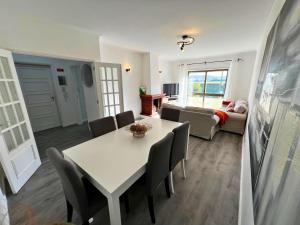 a living room with a table and chairs and a couch at Naval Beach Apartment in Azurara