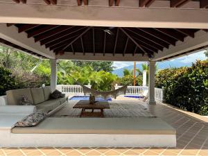 a patio with a couch and a hammock under a pergola at Finca La Verbena in San Jerónimo