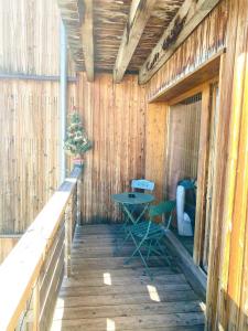een houten veranda met een tafel en een stoel bij Appartement super Devoluy in Le Dévoluy