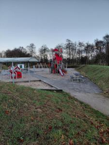 een speeltuin in een park met een rode glijbaan bij Apartment in green area in Grindsted