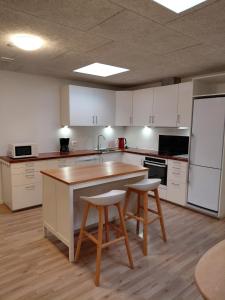 een keuken met witte kasten en een tafel en twee stoelen bij Apartment in green area in Grindsted