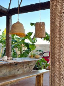 een tafel met twee hanglampen en een bankje bij Villa Papaya in Jomba +21 foto's