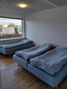 twee bedden in een kamer met een raam bij Apartment in green area in Grindsted