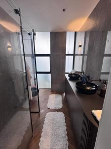 un bagno con doccia in vetro e lavandino di Sky High 15 - Luxury Penthouse with Panoramic View a Beer Sheva