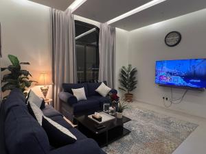ein Wohnzimmer mit einer blauen Couch und einem Fernseher in der Unterkunft شقة خاصة in Dschidda