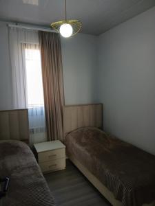 een hotelkamer met twee bedden en een raam bij Elite Guest House in Goris