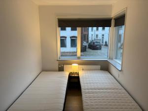 a small room with a bed and a window at Bright and spacious 3 bedroom with balcony close to the city in Aabenraa