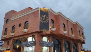 ein großes Backsteingebäude mit einer Uhr darauf in der Unterkunft شقة خاصة in Dschidda
