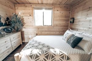a bedroom with a bed in a wooden room at Cozy Cub Cabin, Wilderness Retreat Williams AZ near Grand Canyon, Fire pit in Williams