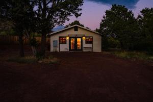 a small house with the door open in a yard at Cozy Cub Cabin, Wilderness Retreat Williams AZ near Grand Canyon, Fire pit in Williams +30 photos