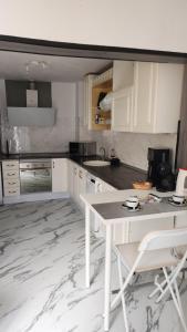 eine Küche mit weißen Schränken und einem Tisch und Stühlen in der Unterkunft MI CASITA de Lanzarote in Arrecife