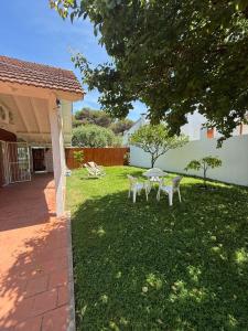 a table and chairs in the yard of a house at CASA El CORRALÓN in Las Toninas +5 photos