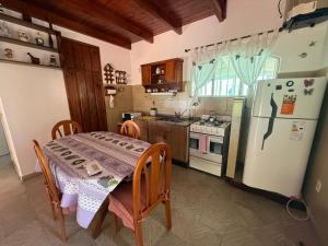 a kitchen with a table and a white refrigerator at CASA El CORRALÓN in Las Toninas