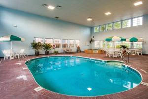 a pool in a room with tables and chairs at Angel Inn - Central in Branson