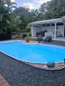 a large blue swimming pool in a yard at Gwadakaz in Sainte-Rose +4 photos