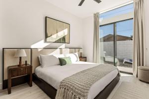 a bedroom with a large bed and a large window at Desert Oasis: Pool, Spa, Golf Sim + EV Charger in Bermuda Dunes