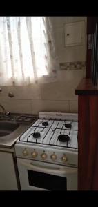 een keuken met een fornuis, een wastafel en een raam bij PH en Mar de Ajó Centro in Mar de Ajó +1 foto