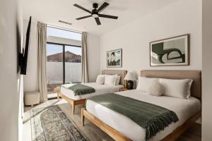 a bedroom with two beds and a ceiling fan at Desert Oasis: Pool, Spa, Golf Sim + EV Charger in Bermuda Dunes +67 photos
