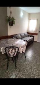 een slaapkamer met een bed, een tafel en een bank bij PH en Mar de Ajó Centro in Mar de Ajó